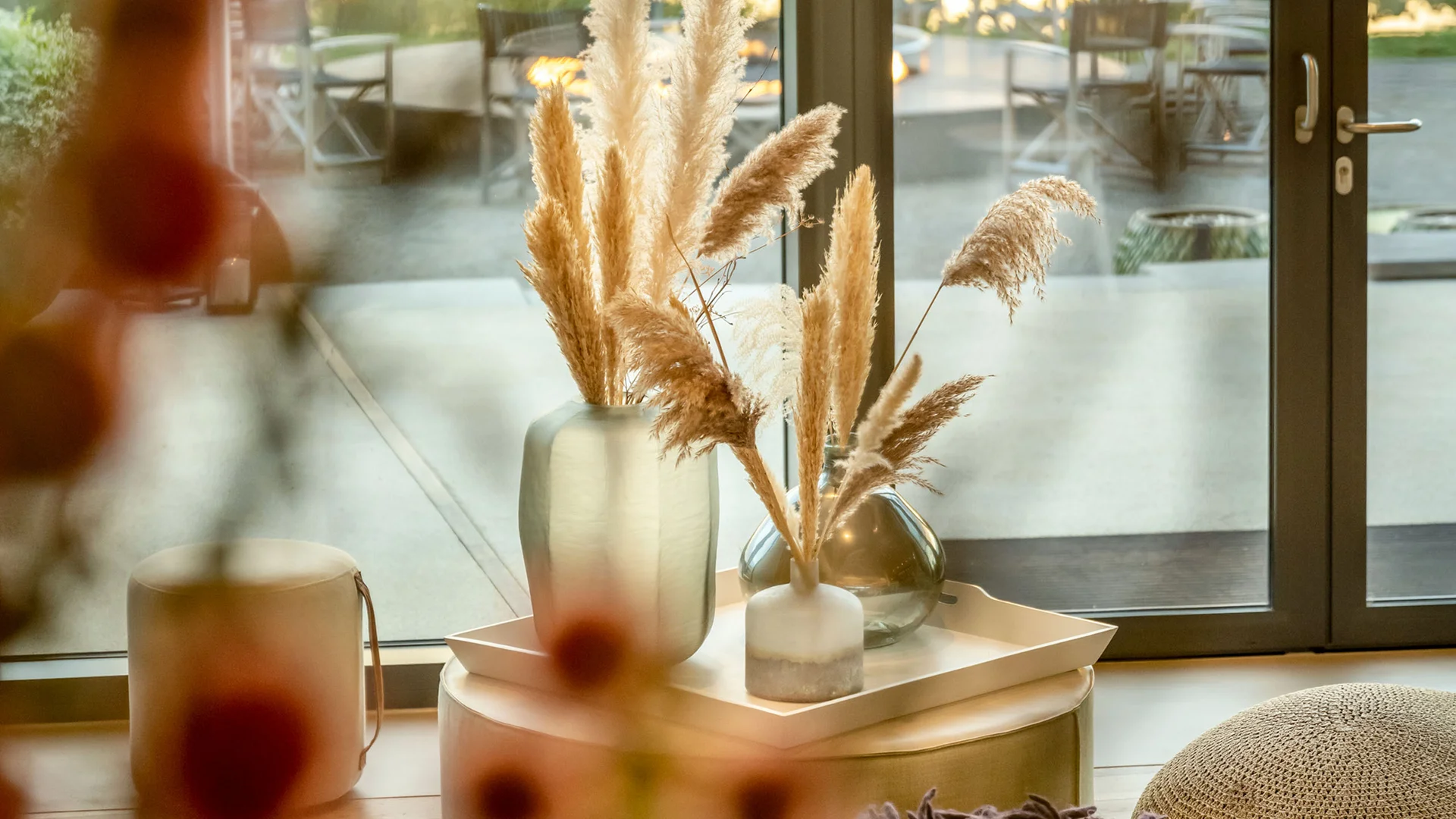 Wohnzimmer mit Glasfenstern und Vase mit getrocknetem Pampasgras
