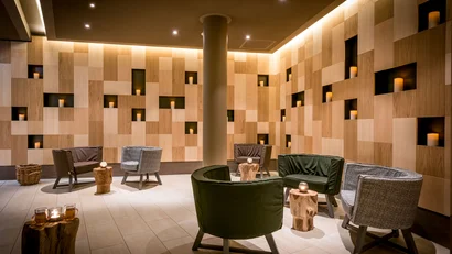 Gemütlicher Lounge-Bereich mit Holzpaneelen und Kerzenbeleuchtung