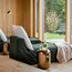 Entspannungsbereich mit Liegen, Kissen und Wasser in einem modernen Holzinterieur