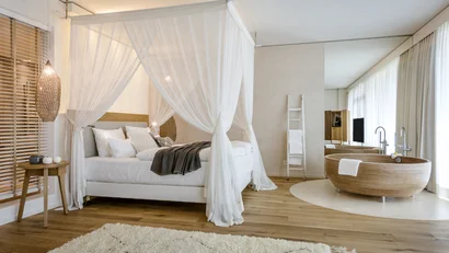 Modernes Schlafzimmer mit Himmelbett und freistehender Badewanne aus Holz