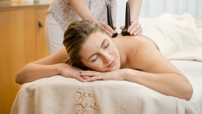 Eine Frau erhält eine Steinerne Rückenmassage im Spa