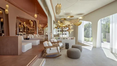Modernes Lounge mit natürlichen Materialien und großen Fenstern mit Blick ins Grüne