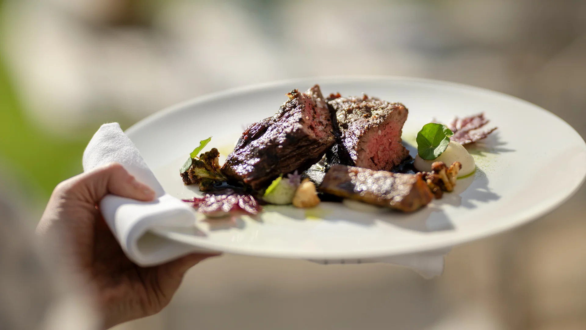 Vorspeise mit gegrilltem Fleisch und Gemüse auf weißem Teller im Freien