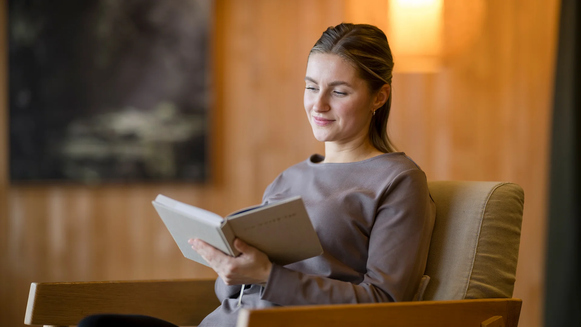 Frau entspannt lesend in einem gemütlichen Sessel
