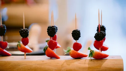 Brombeeren, Himbeeren und Erdbeeren auf Holzspießen in Holzblock gesteckt