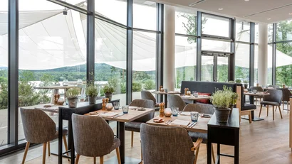 Modernes Restaurant mit großen Fenstern und Blick auf die Natur