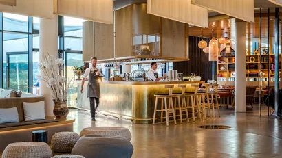Moderner Hotelbarbereich mit einem Barkeeper und bequemen Sitzgelegenheiten