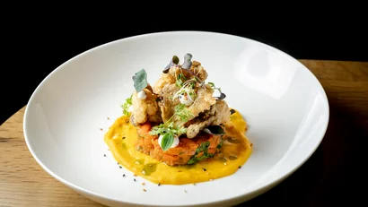 Elegantes Gemüsegericht mit cremiger Sauce und Kräutern auf weißem Teller