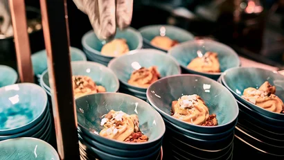 Kleine Dessertportionen in blauen Schüsseln, werden serviert.