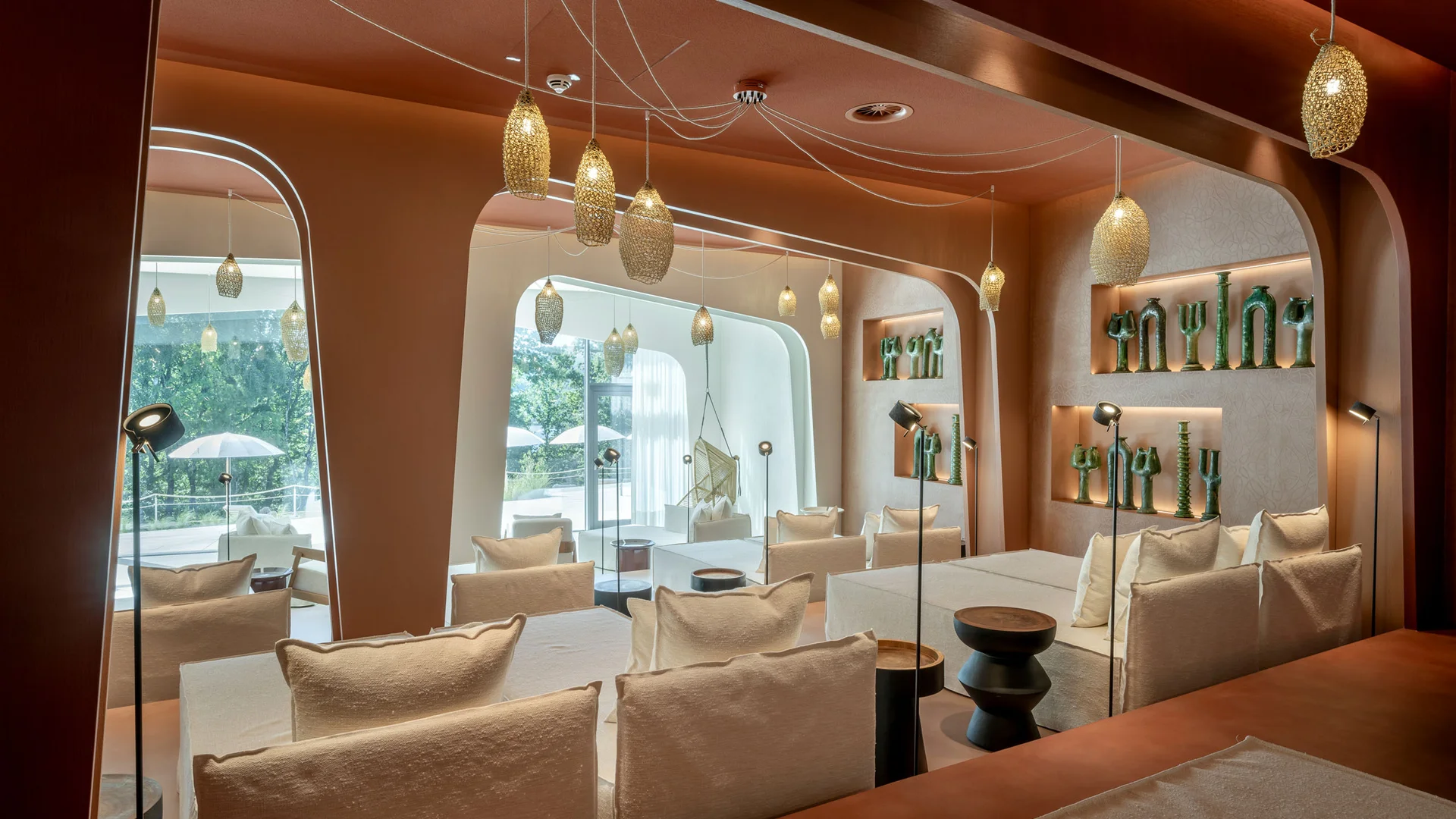 Modernes Wohnzimmer mit weißen Sofas, Hängelampen und dekorativen grünen Vasen