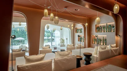 Modernes Wohnzimmer mit weißen Sofas, Hängelampen und dekorativen grünen Vasen