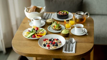 Gesundes Frühstück mit Obst, Gemüse, Kuchen, Tee und Saft auf einem Holztisch