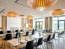 Modernes Tagungszimmer mit Tischen, Stühlen und Flüssigkeiten vorbereitet