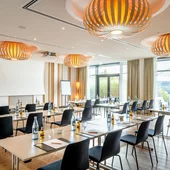 Modernes Tagungszimmer mit Tischen, Stühlen und Flüssigkeiten vorbereitet