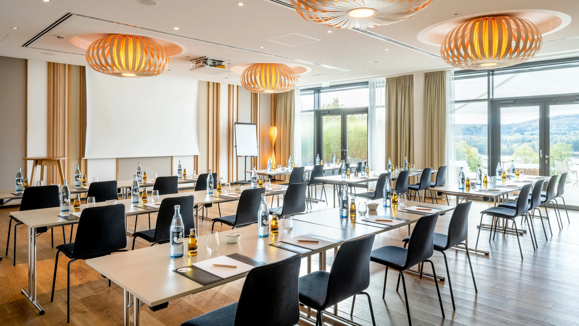 Modernes Tagungszimmer mit Tischen, Stühlen und Flüssigkeiten vorbereitet