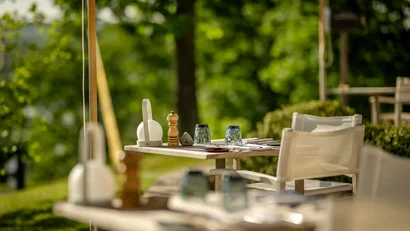 Leerer Gartentisch im Freien mit Gläsern und Gewürzen